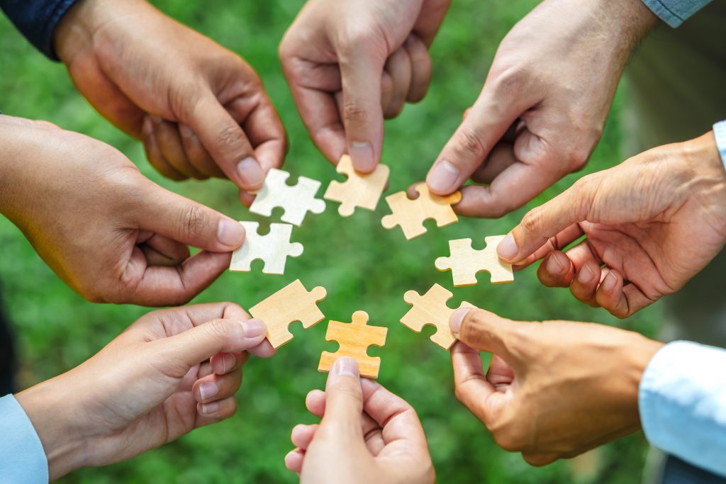 World environment day and ESG Concept of teamwork and partnership Hands join Jigsaw puzzle pieces with global community sustainable Save Earth. the Environment World Earth Day concept